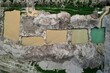 A top-down aerial view of several slurry wastewater pits at a concrete batching plant yard. They are used to contain and process waste materials generated during the production of concrete