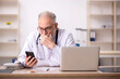 © Elnur - Old male doctor in telemedicine concept