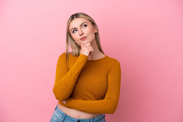 Wall Mural - Young caucasian woman isolated on pink background having doubts