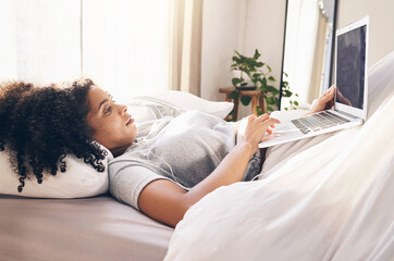 Canvas Print - Music earphones, laptop and woman in bed in bedroom for social media or internet browsing in the morning. Technology, relax or black female with computer for streaming podcast, audio or radio in home