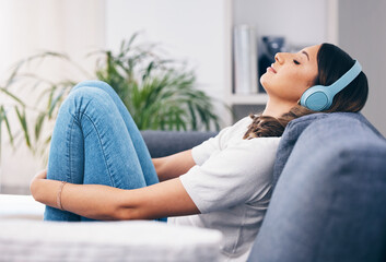 Canvas Print - Music, relax and quiet with a woman in her home, listening to the radio while sitting on the living room sofa. Peace, wellness or headphones with an attractive young female streaming audio in a house