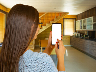 Poster - Woman with phone. Girl is holding smartphone with white screen. Lady with phone inside house. Place to showcase apps or website. Woman uses stylus for mobile phone. Concept using IoT. Art focus