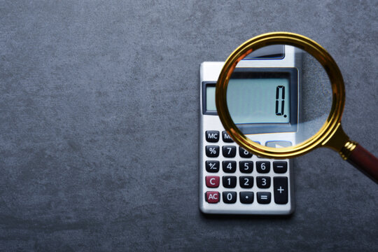 financal concepts, a calculator showing zero with magnifying glass