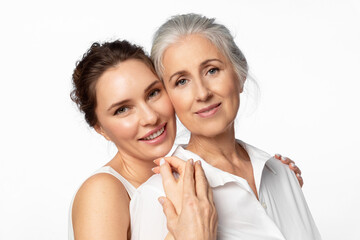 young beautiful woman and her mother looking happily into the frame together