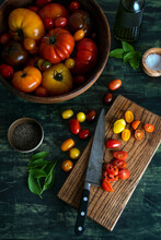 Heirloom and cherry tomatoes in wood bowl and on a cutting board