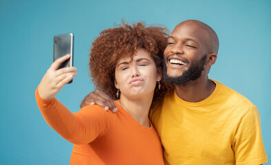 Wall Mural - Couple, bonding or funny faces selfie on blue background, isolated mockup or wall mock up on social media. Comic, goofy or silly man and woman on photography technology in interracial profile picture