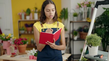 Wall Mural - Young african american woman florist smiling confident writing on notebook at flower shop