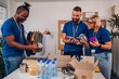 © Zamrznuti tonovi - Diverse volunteers working in a charity donation center and packing clothes and food