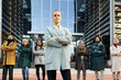 © CarlosBarquero - The woman director of the company poses with her team in front of the corporate building. Business people follow the leader to success and female empowerment. High quality photo