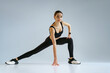 © Yaroslav Astakhov - Sport woman stretching legs. Warm up before training on studio background