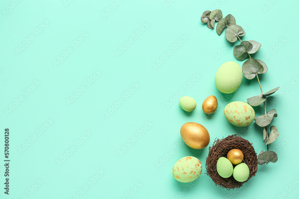 Composition with painted Easter eggs and eucalyptus branch on color background