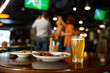 © Nomad_Soul - Beer glass and fast food snack on table in sports bar