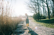 © Cavan Images - young girl walking along a coastal path in a dress at sunset