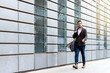 © Cavan Images - Young bearded man walking on the street next to office building