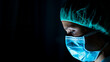 © Cavan Images - Portrait of young female surgeon, wearing mask and a surgical mask, in front of black background