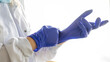 © Cavan Images - Medicine and Surgery theme: female nurse putting on protective blue gloves