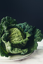 Ripe Leafy Green Savoy Cabbage Head On Marble And Dark Background