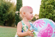 Baby Girl Two Years Old Plays Balloons On The Grass, Summer Party