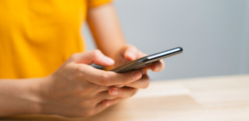 Wall Mural - Hand holding smartphone with using social media on internet on table.