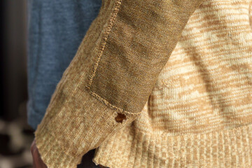 detail of men sleeve patch fragment. wool sweater, selective focus. concept needlework, recycling an