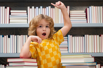 Idea. Knowledge day. Child reads books in the library. Schoolkid with book in school library. Kids literature for reading. Learning from books. School education and clever talented pupil genius.