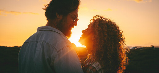 Man and woman adult relationship in outdoor love leisure activity enjoying golden sunset and looking each other with love and tenderness. People attraction lifestyle. Emotions and feeling on vacation