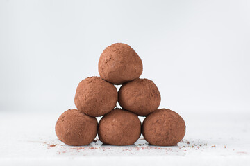 chocolate truffles covered in cocoa powder, homemade chocolate bonbons on white background