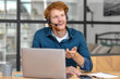 © kucherav - Young caucasian man entrepreneur works with laptop and headset, discussing something, sitting in the home office