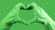 Heart-shaped sign, gesture with hand in green gloves of cleaner, cleaning service with love concept