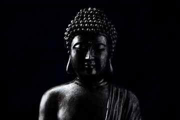 Wall Mural - Meditating Buddha Statue on dark background. Soft focus. Close up. Copy space.	