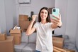 © Krakenimages.com - Young beautiful hispanic woman having video call holding key at new home