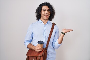 Wall Mural - Hispanic man with curly hair drinking a cup of take away coffee pointing aside with hands open palms showing copy space, presenting advertisement smiling excited happy