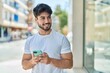 © Krakenimages.com - Young hispanic man smiling confident using smartphone at street
