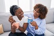 © Krakenimages.com - African american women mother and daughter drinking coffee at home