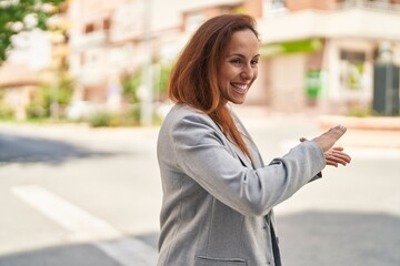 Canvas Print - Young woman executive doing spend money gesture at street