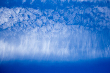 Blue morning sky with unusual white descending clouds