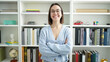 © Krakenimages.com - Young beautiful hispanic woman student smiling confident standing with arms crossed gesture at library university