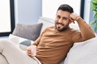 © Krakenimages.com - Young hispanic man drinking coffee sitting on sofa at home