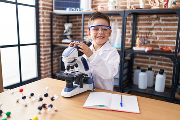 Poster - Adorable hispanic boy student smiling confident using microscope at laboratory classroom