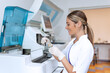 Lab tech loading samples into a chemistry analyzer. female lab tech loading specimen for coagulation test analysis