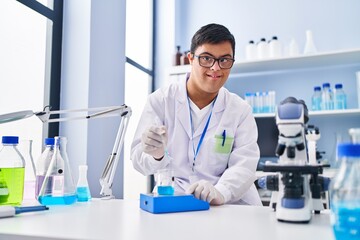 Sticker - Down syndrome man wearing scientist uniform measuring liquid at laboratory