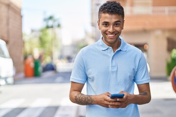 Poster - African american man smiling confident using smartphone at street