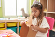 © Krakenimages.com - Adorable blonde girl student wearing princess crown cutting paper at kindergarten