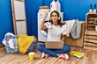 © Krakenimages.com - Young hispanic woman studying while waiting for laundry angry and mad raising fist frustrated and furious while shouting with anger. rage and aggressive concept.