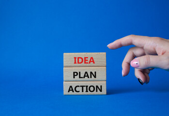 Wall Mural - Idea Plan Action symbol. Wooden blocks with words Idea Plan Action. Businessman hand. Beautiful blue background. Business and Idea Plan Action concept. Copy space.