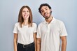 © Krakenimages.com - Young couple wearing casual clothes standing together sticking tongue out happy with funny expression. emotion concept.