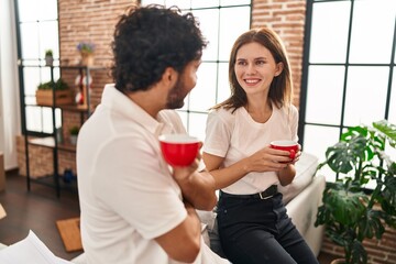 Canvas Print - Man and woman couple smiling confident drinking coffee at new home