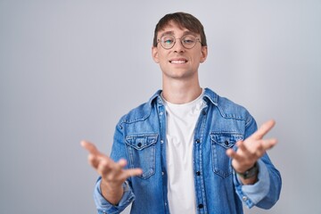 Sticker - Caucasian blond man standing wearing glasses smiling cheerful offering hands giving assistance and acceptance.