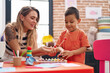 © Krakenimages.com - Teacher and toddler playing xylophone sitting on table at kindergarten