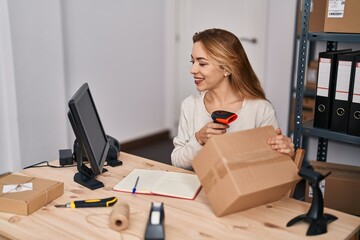 Young woman ecommerce busines worker scanning package at office